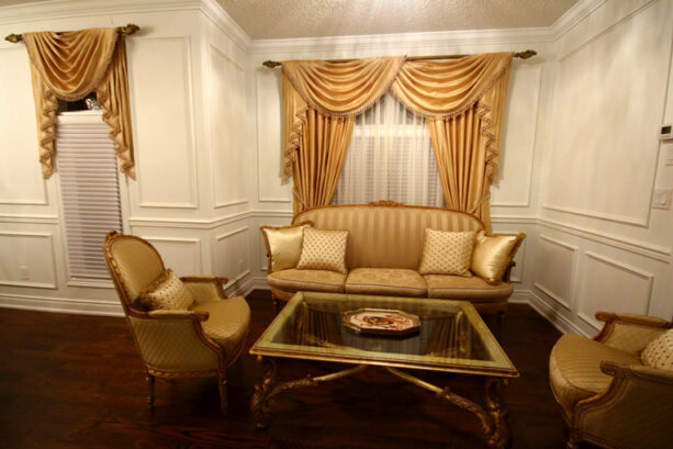 a living room with white walls and gold drapery is a stunning house of grandeur