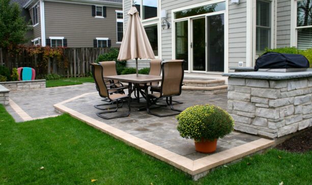 a raised patio with brick surfaces, limestone seat walls, and clay accent paver is so pleasing to the eyes