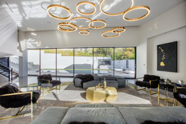 a striking white living room with a gold chandelier