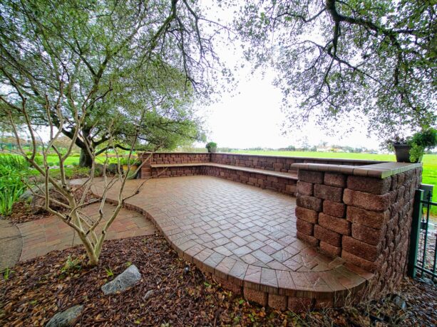 a totally red raised patio with a red concrete paver and seat walls