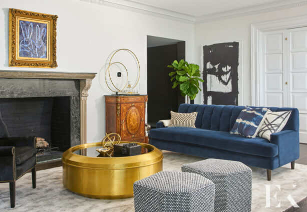 a white living room with a flashy gold round-top table welcomes the addition of a blue sofa
