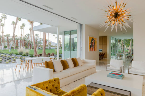 a white sofa and gold armchairs bring splendor into a mid-century modern living room