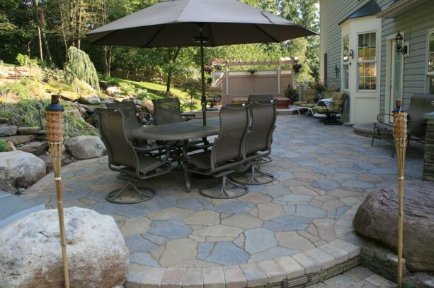 the beauty comes in the form of a raised paver patio with a brick perimeter and a slab stone inlay