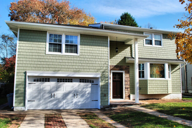 a bright exterior is created by the use of a vinyl shake sage green siding