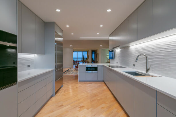 a modern galley kitchen with a grey peninsula