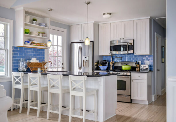 a peninsula with a black countertop in a beach style galley kitchen