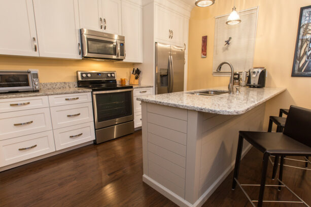 a peninsula with a granite countertop in a minimalist galley kitchen