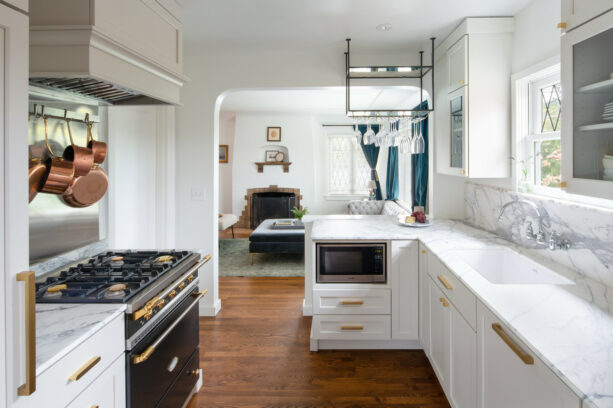 a peninsula with a marble countertop in an elegant galley kitchen