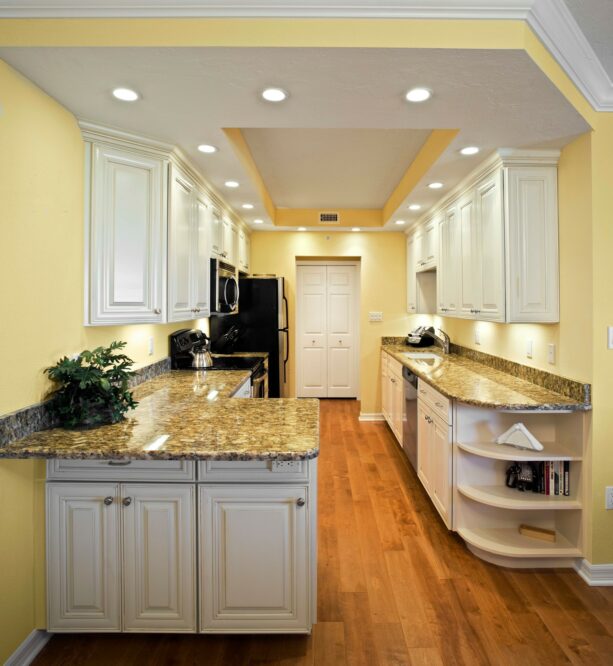 a peninsula with a multicolored countertop in a yellow galley kitchen