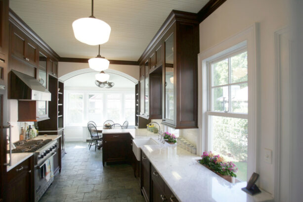 a victorian galley kitchen with a dark brown peninsula